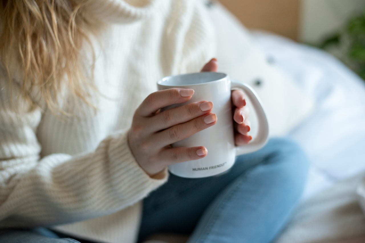 Ernährung bei Parkinson: Frau hält Tasse in beiden Händen